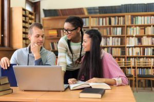 Three high school students studying at library